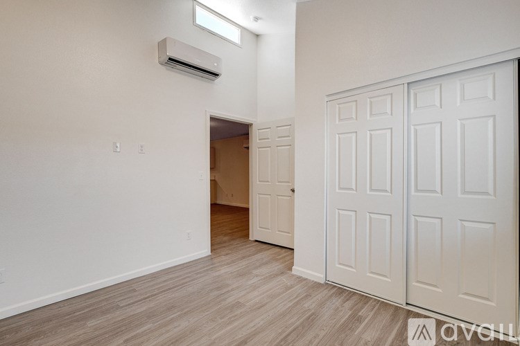 A room with a white door and a wall-mounted air conditioner.