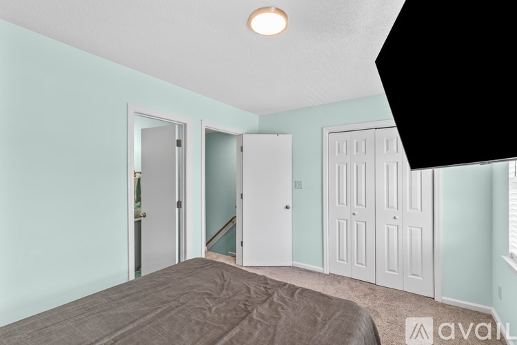 A bedroom with a bed, a window, and a door.