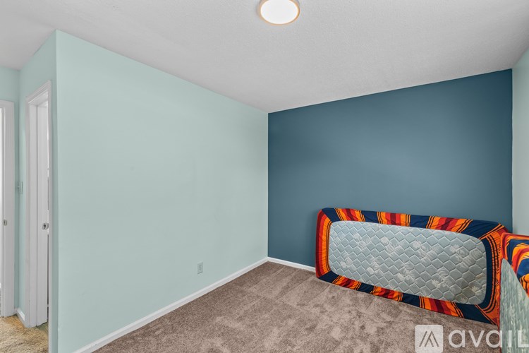 A room with a bed and a carpet.