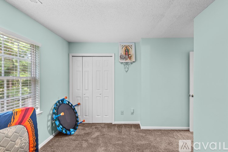 A room with a white door and a framed picture on the wall.
