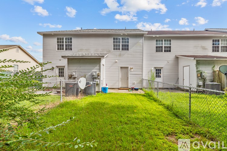 A house with a fence and a green lawn in front.