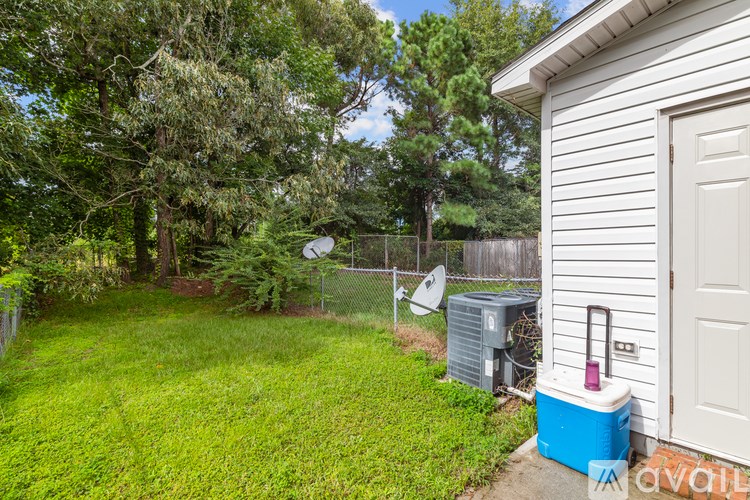 A backyard with a fence, a shed, and a cooler.