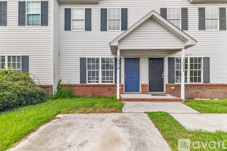 A house with a blue door and a brick wall.