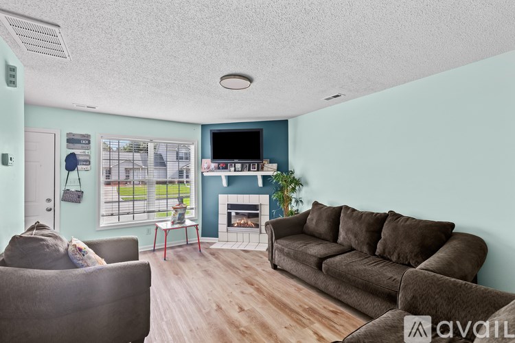 A living room with a grey couch, a red table, and a television.