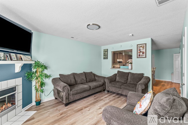 A living room with a grey couch and a fireplace.