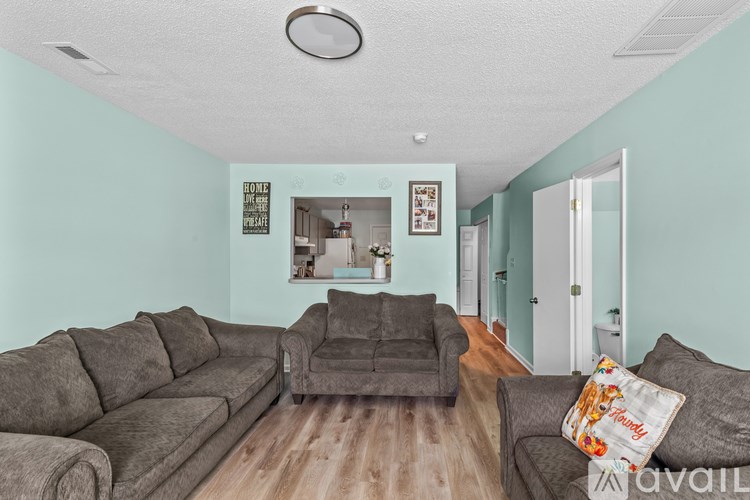 A living room with a grey sofa and a wooden floor.