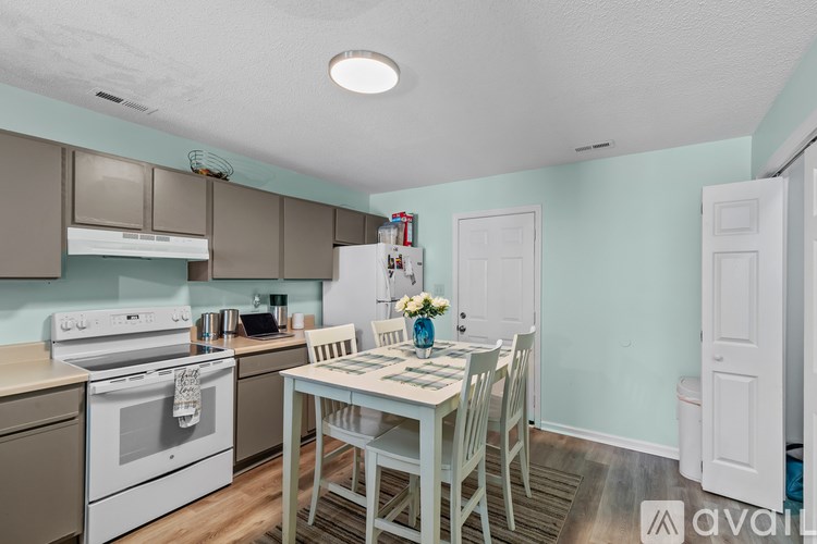 A kitchen with a table and chairs in the middle of the room.