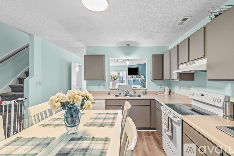 A kitchen with a table set for two and a vase of flowers.
