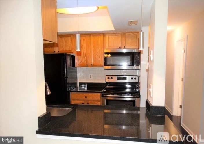 A kitchen with black appliances and wooden cabinets.