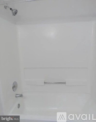 A white bathroom with a shower and a towel bar.