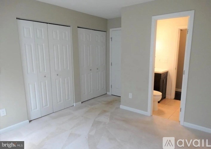 A room with white doors and a man standing in the doorway.