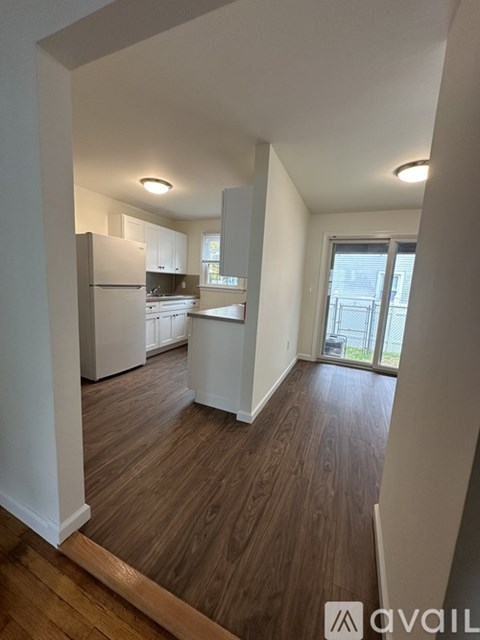 A kitchen with white cabinets and a refrigerator.