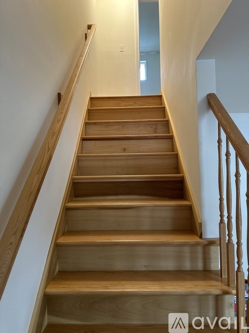 A wooden staircase with a railing on the side.