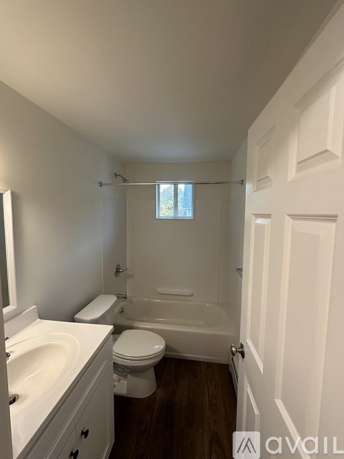 A bathroom with a toilet, sink, and bathtub.