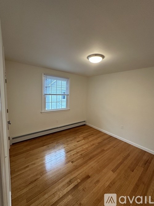 A room with wooden flooring and a window.