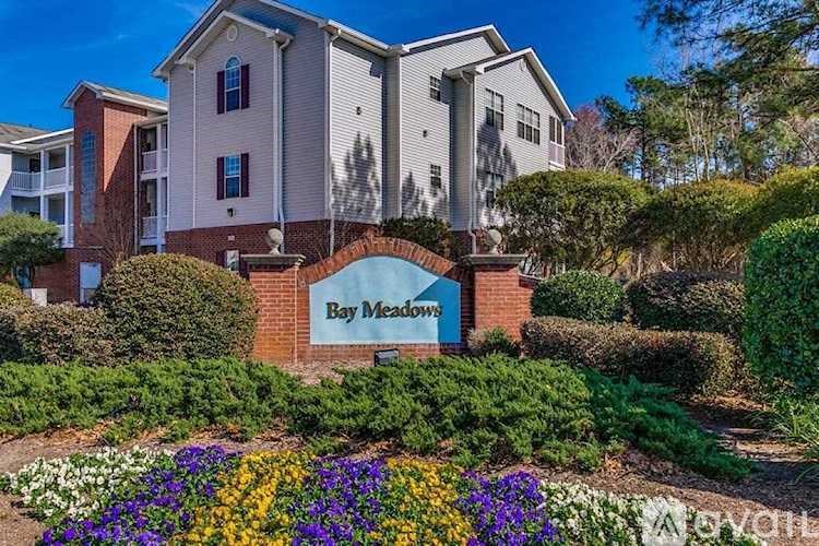 A sign that says Bay Meadows in front of a building.