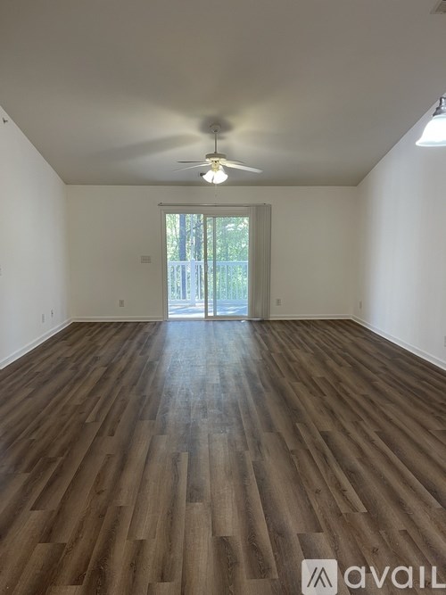 A room with wooden flooring and a ceiling fan.