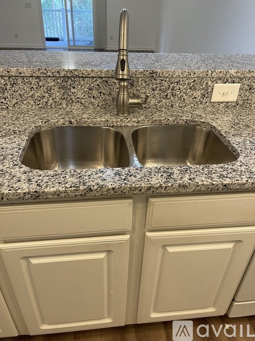 A granite countertop with a double sink and a faucet.