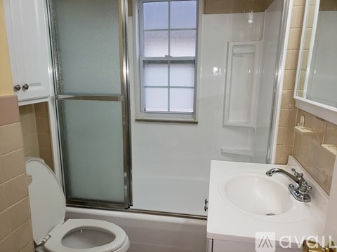 A white toilet with a glass door shower in a bathroom.