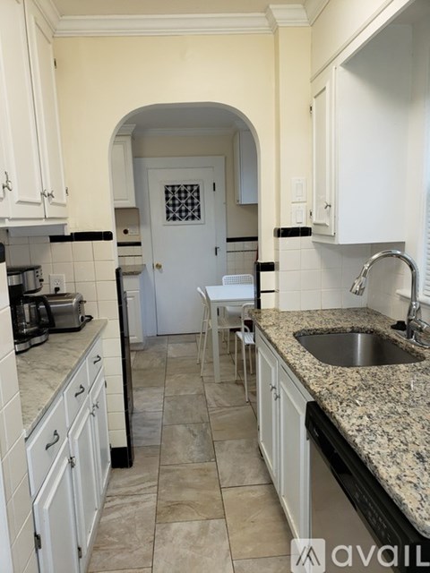 A kitchen with a granite countertop and white cabinets.