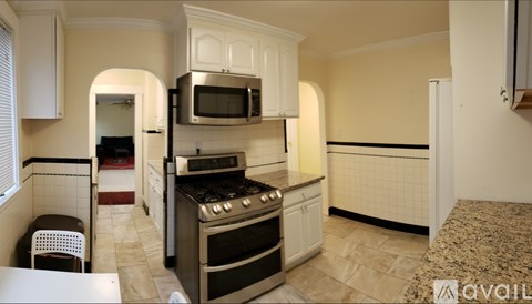 A kitchen with white appliances and cabinets.