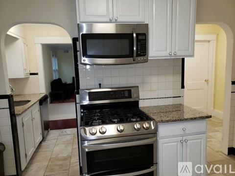 A kitchen with a stove, microwave, and cabinets.