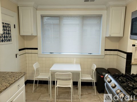 A kitchen with a table and chairs by the window.