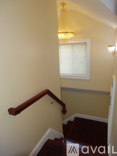 A staircase with a chandelier hanging above it.