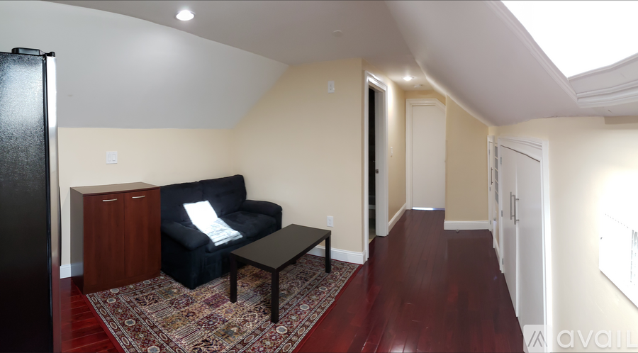 A living room with a black couch and a coffee table.