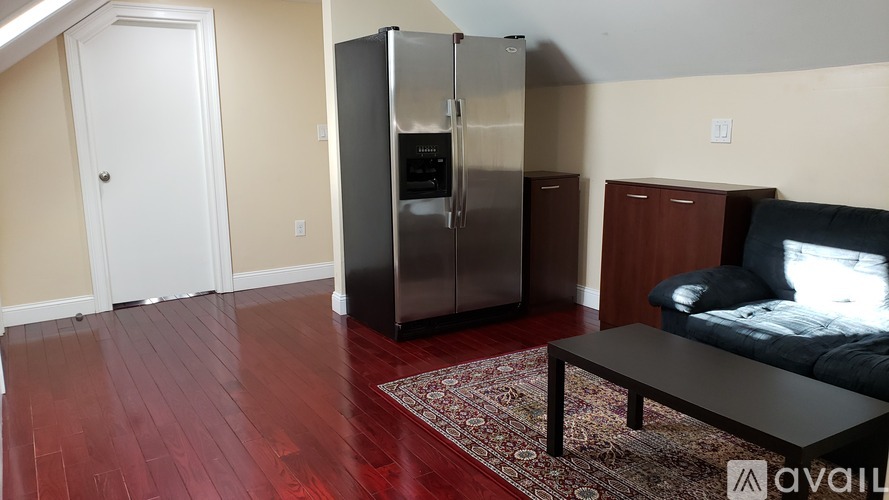 A kitchen with a refrigerator, a door, and a table.