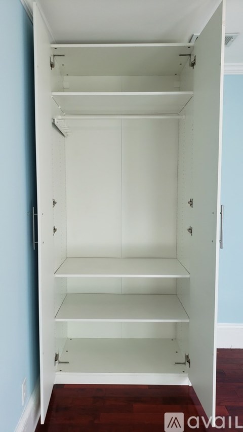 A white closet with shelves and a door open.
