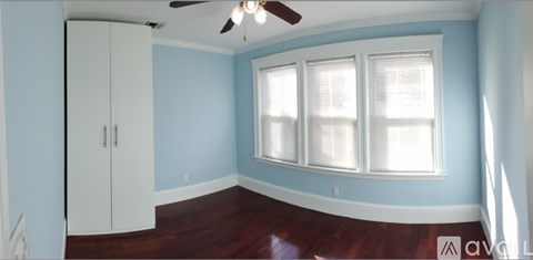 A room with a white door and a ceiling fan.