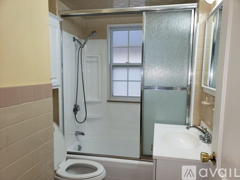 A bathroom with a toilet, sink, and shower.