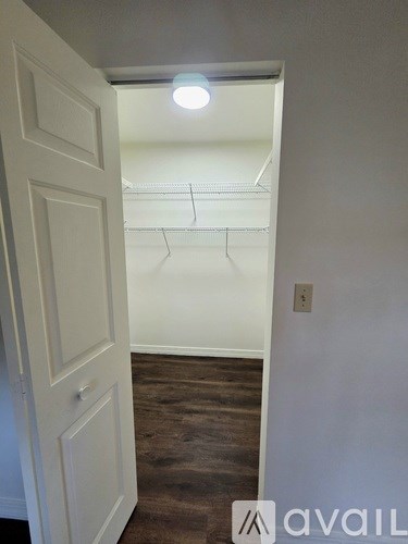 A white door is open to a room with a light on.