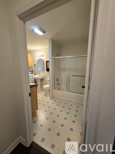 A bathroom with a toilet, sink, and shower.