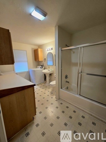 A bathroom with a tiled floor and a walk-in shower.
