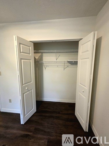 A room with a white door and a white closet with a shelf.