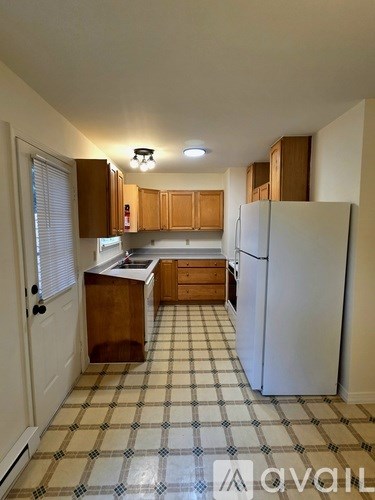 A kitchen with a checkered floor and white appliances.