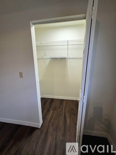 A room with a white door and a wooden floor.