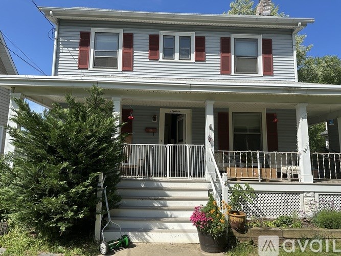 A house with a porch and a green lawnmower on the steps.