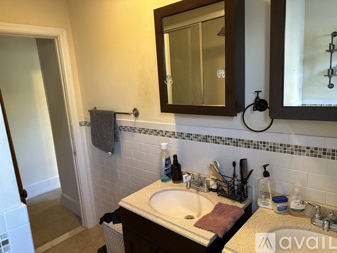 A bathroom with a sink, mirror, and toiletries.