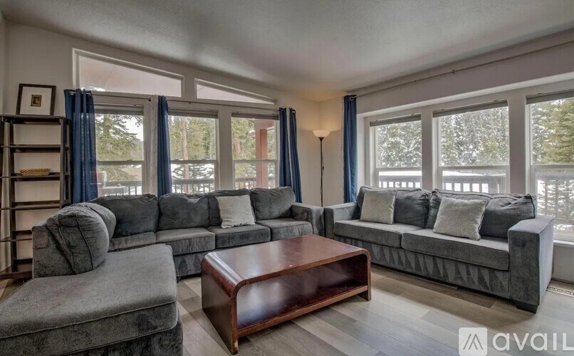 A living room with grey couches and a wooden coffee table.