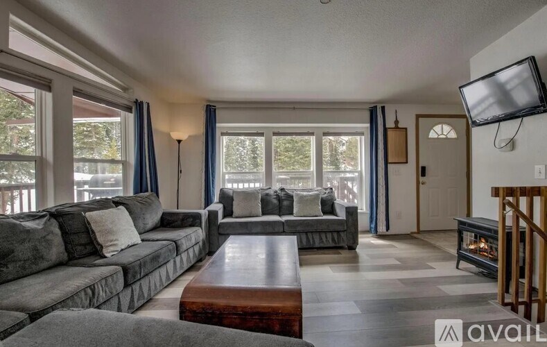 A living room with a grey couch and a wooden coffee table.