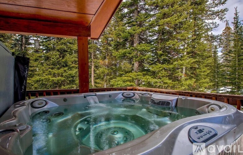 A hot tub on a balcony with trees in the background.