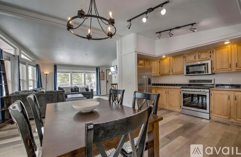 A modern kitchen with wooden cabinets and a dining table set for four.