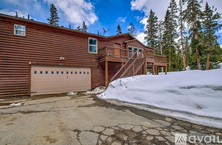 A wooden house with a closed brown garage door.