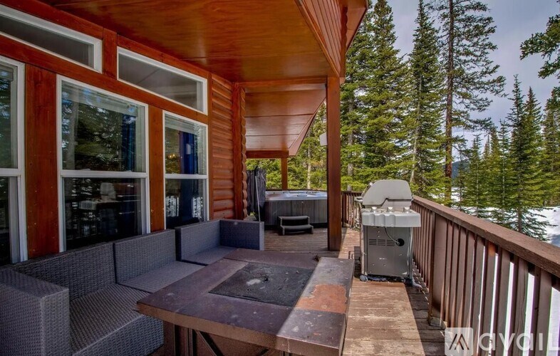 A wooden deck with a hot tub and a grill.