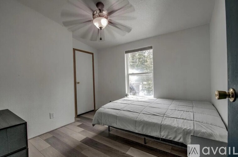 A bedroom with a bed, dresser, and window.