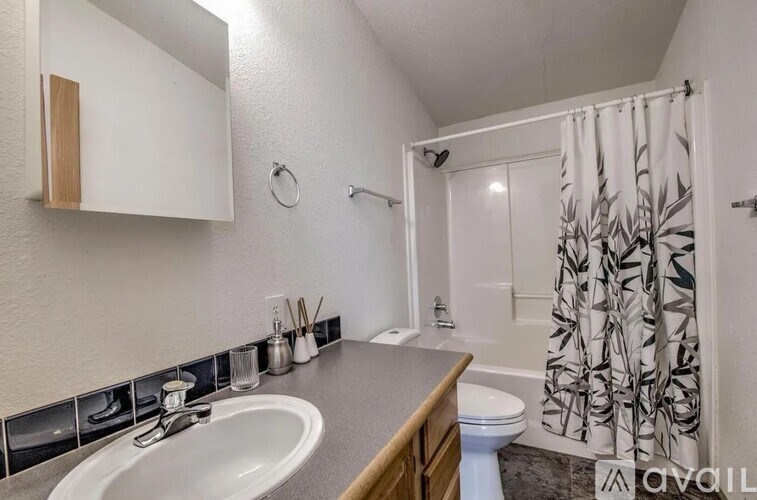 A bathroom with a sink, toilet, and shower.