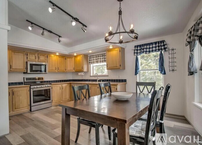 A kitchen with wooden cabinets and a large island with chairs around it.